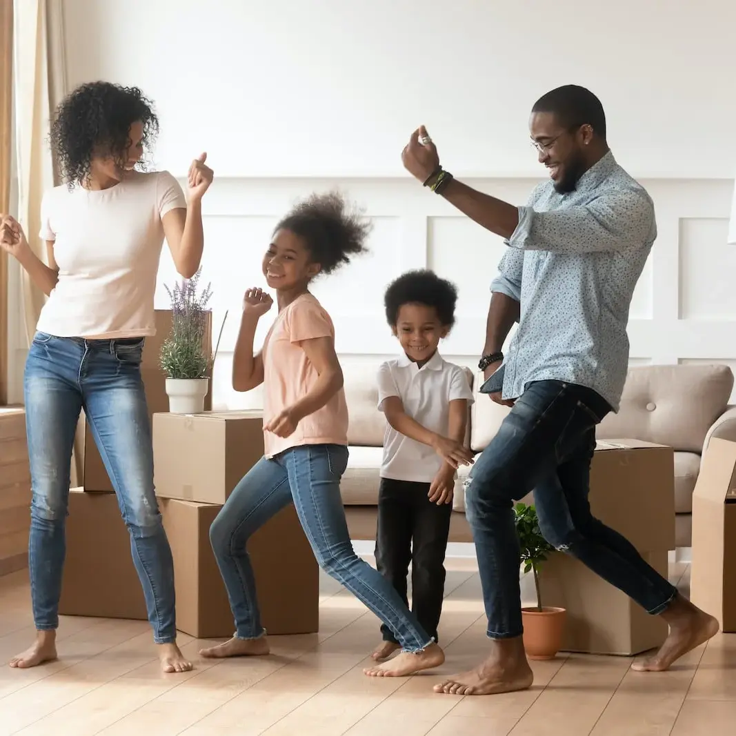 family dancing in home after unpacking boxes