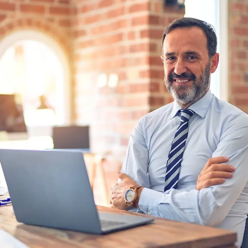 business man at desk smiling