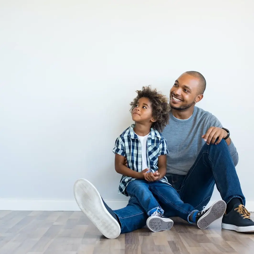 father and son sitting on floor